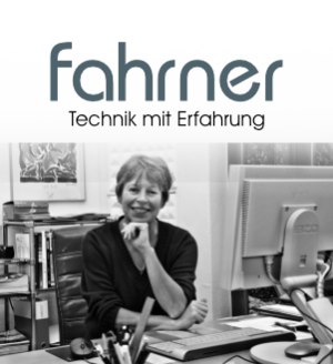Logo mit Christine Fahrner am Schreibtisch Logo mit Christine Fahrner am Schreibtisch
